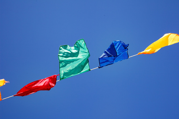 Bandeiras Bunting soprando no vento contra um céu azul
 - Foto, Imagem