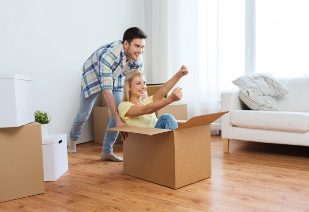 happy couple having fun with boxes at new home - Photo, Image