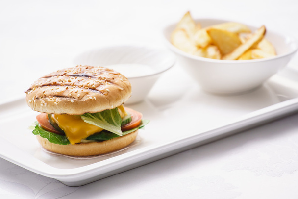 Ízletes sajtburger sültkrumplival - Fotó, kép
