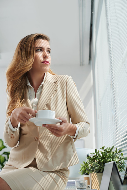 Улыбающаяся деловая женщина с чашкой кофе
 - Фото, изображение