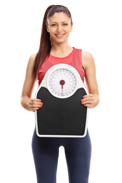 Beautiful woman holding a weight scale  - Фото, изображение