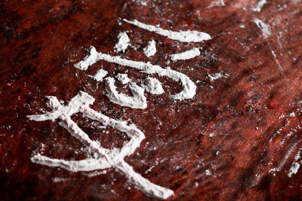 japanese hieroglyph with flour, which means love, a dark old rustic background - Photo, Image