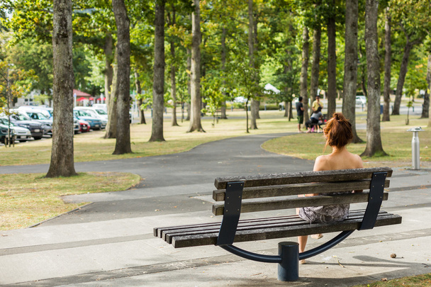 Woman sitting on a bench in the park - Foto, Imagen