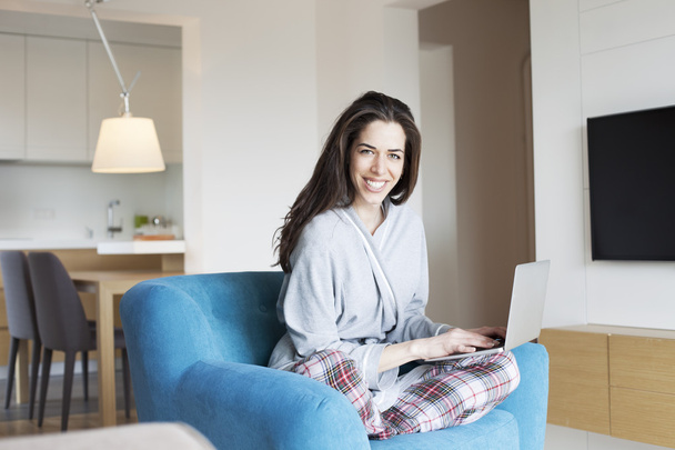 Woman sitting in sofa in the living room. Morning scene,woman smiling working on laptop - Foto, Imagem