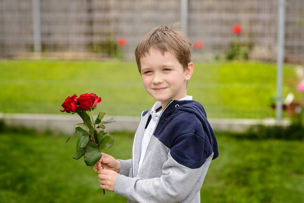 Petit garçon tenant un bouquet de roses
 - Photo, image