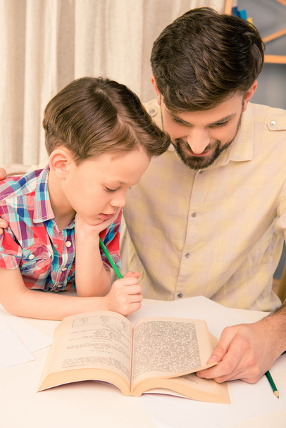 Close up portrait of handsome  father reading book to his son - Foto, immagini