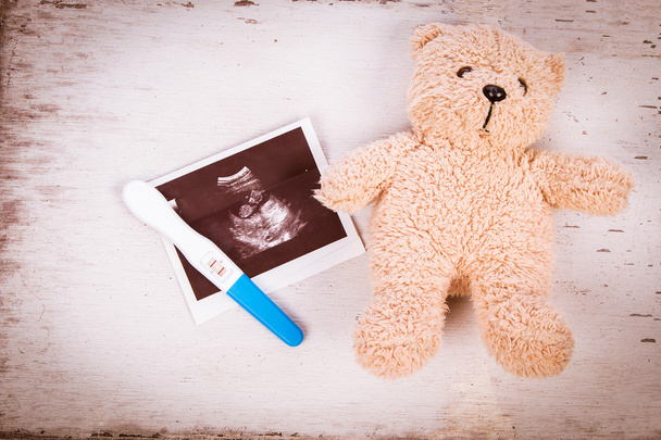 USG z testem ciążowym na drewnianym tle - Zdjęcie, obraz