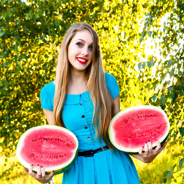 Smiling young woman holding two halfs of watermelon - Foto, Imagen