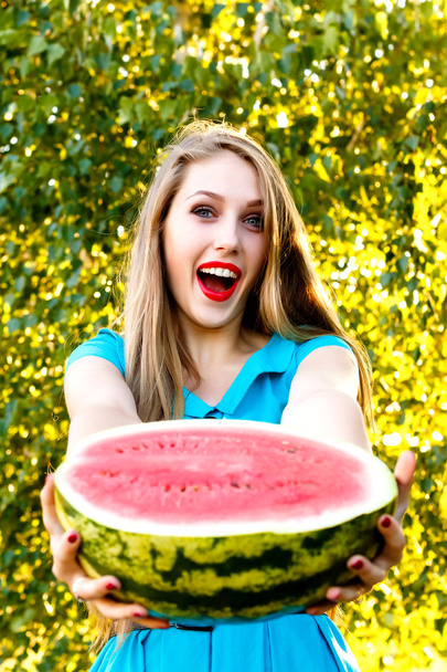 Beautiful blonde girl holding a sliced watermelon - Photo, Image