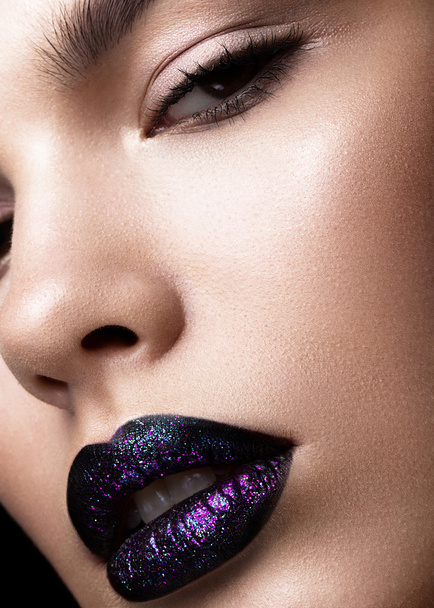 Portrait of a beautiful girl. Brilliant glossy lips closeup. Purple glitter on black lipstick - Foto, afbeelding