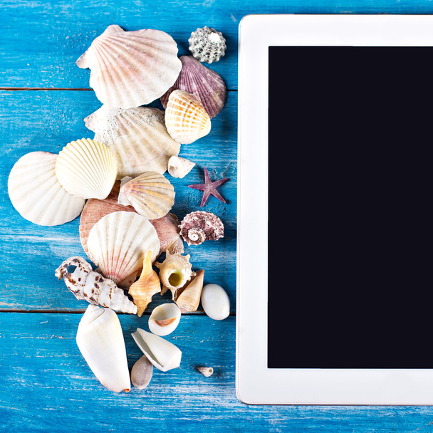 tablet, seashells, blue wood background - Foto, immagini