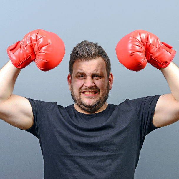 Portrait of chubby boxer posing with boxing gloves as a champion - Foto, imagen