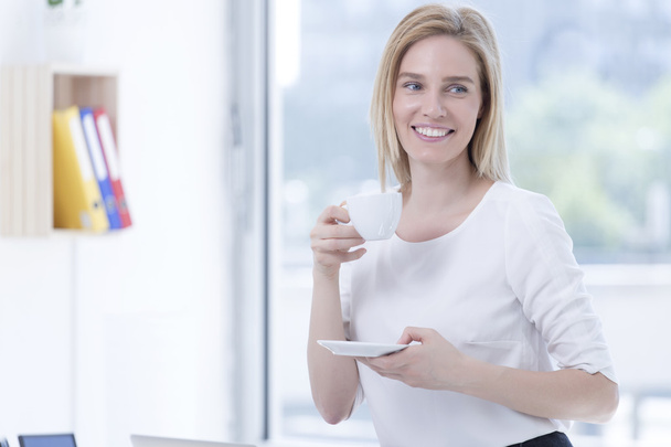 businesswoman in office drinking coffee - Foto, Bild