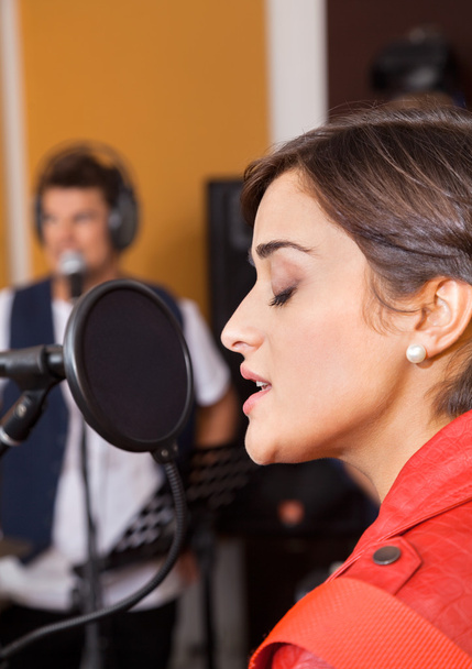 Woman With Eyes Closed Singing In Studio - Foto, afbeelding
