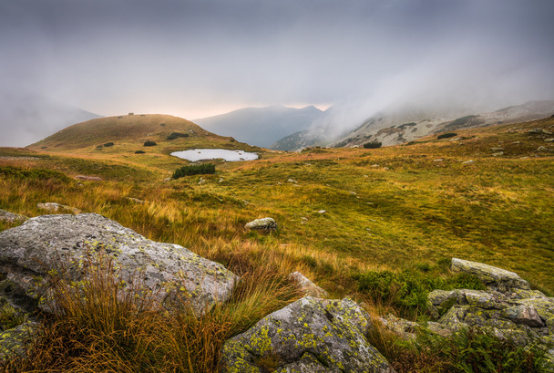 Foggy Mountain Landscape with a Tarn at Sunset - 写真・画像