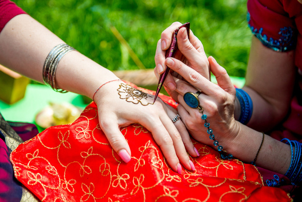 Foto de mano humana siendo decorada con tatuaje de henna, mehendi
  - Foto, Imagen