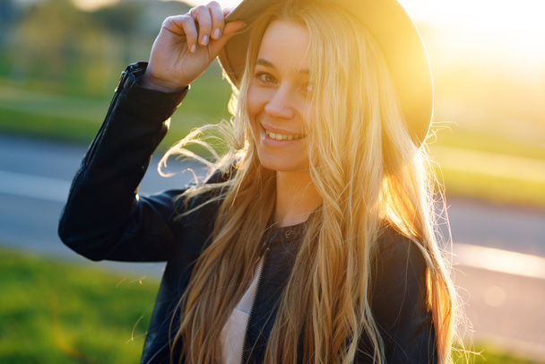 Beautiful girl in a hat walking in the summer on a sunny day and smiling - Foto, Imagen