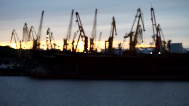 Siluetas de grúas en el puerto sobre el río
 - Imágenes, Vídeo