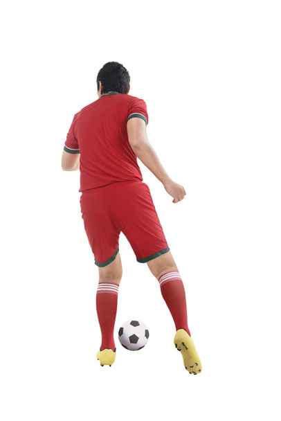 Back view of asian football player kick ball - Foto, afbeelding