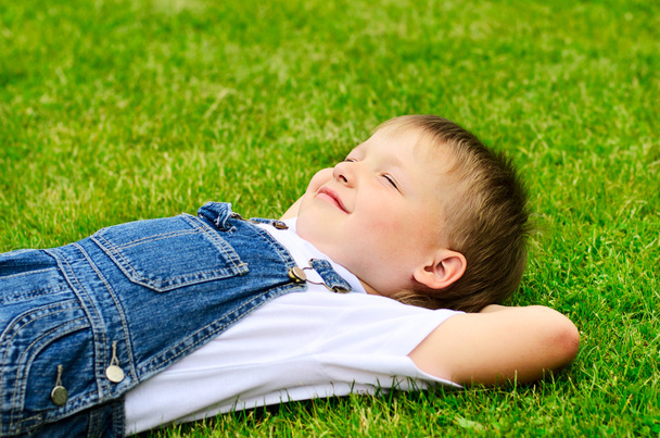 Enfant de 4 ans couché sur l'herbe
. - Photo, image