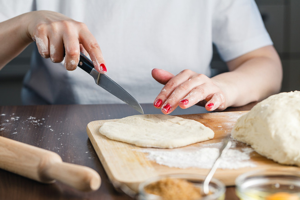woman cuts the dough for preparing cookies - Foto, immagini