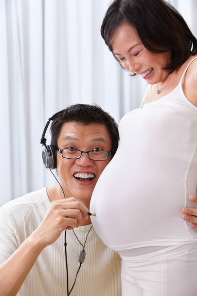 Concept of husband trying to hear fetus sound - Photo, Image