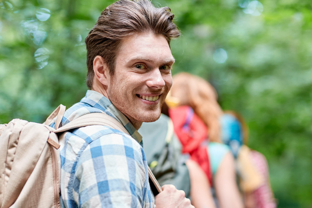 group of smiling friends with backpacks hiking - 写真・画像