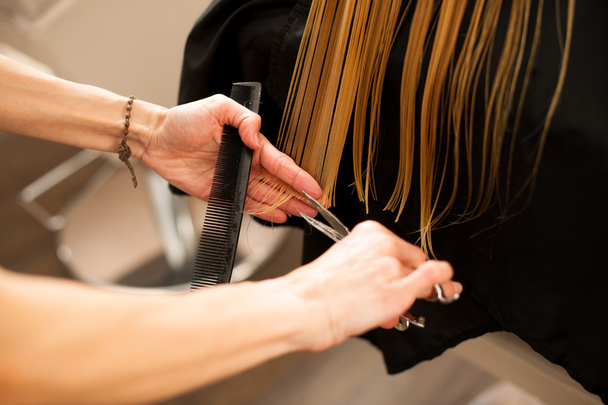 Hair stylist at work - hairdresser cutting hair to the customer  - Foto, imagen