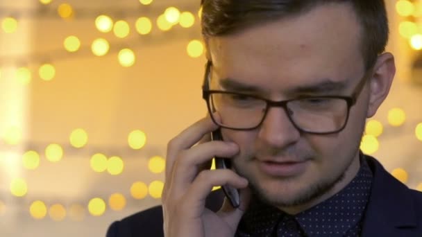 Portrait of businessman in the glasses, talking on the phone and smiling. Slowly - Кадры, видео