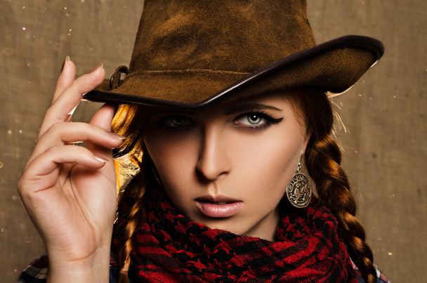 portrait of a beautiful young red-haired girl in a cowboy hat - 写真・画像