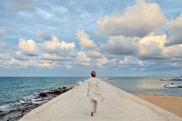 femme marchant sur le quai par une journée venteuse, Ostuni, Pouilles, Italie
 - Photo, image
