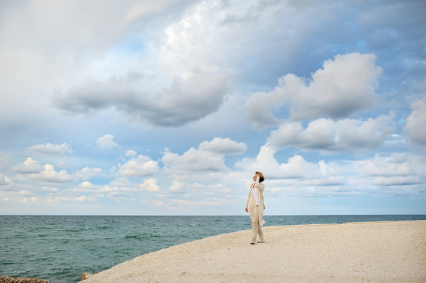 woman looking at the sea, on background cloudy sky - concetual image, Ostuni, Apulia, Italy - Photo, Image