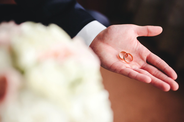 Gold wedding rings on groom's palm - Photo, Image