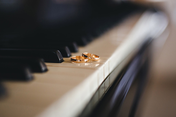 Dvě krásné snubní prsteny na piano klávesnici v detail - Fotografie, Obrázek