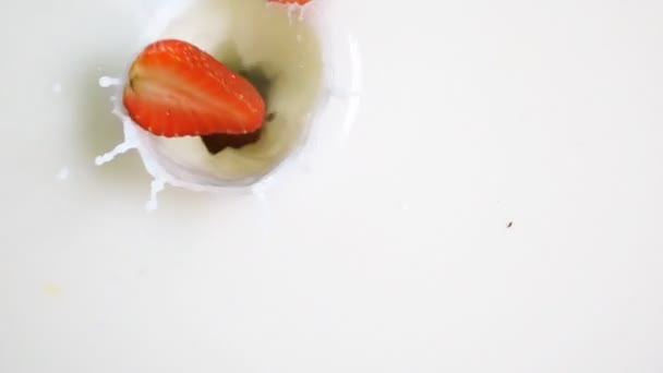 Upuść kawałki truskawek do mleka - Materiał filmowy, wideo