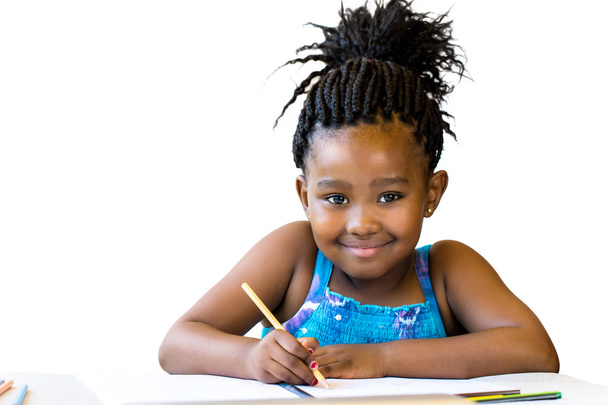 Menina africana segurando lápis na mesa
. - Foto, Imagem