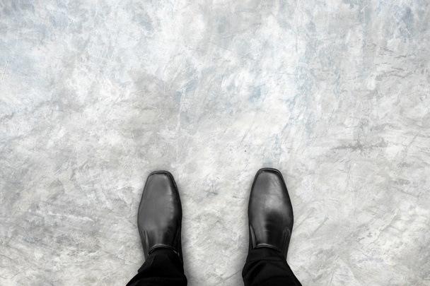 Zwarte schoenen staan op betonnen vloer - Foto, afbeelding