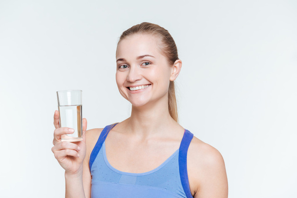 Smiling fitness woman holding glass with water  - Valokuva, kuva