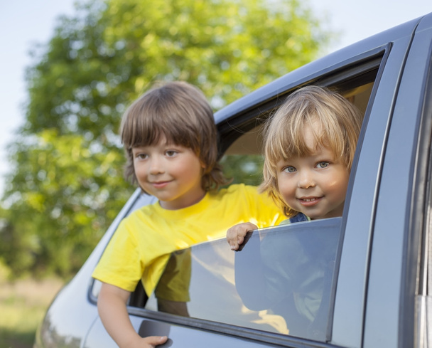 two cheerful child sitting in the car - Valokuva, kuva