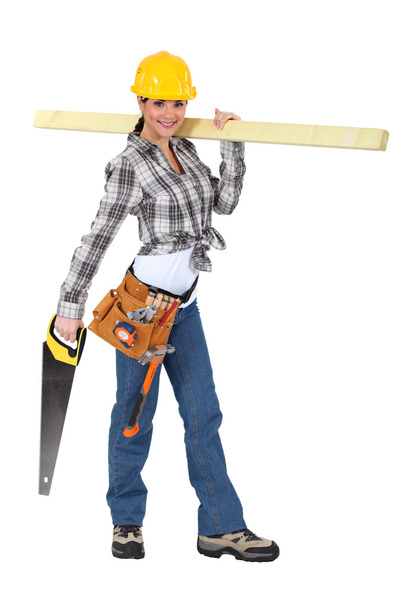 Female carpenter carrying plank of wood - Foto, afbeelding
