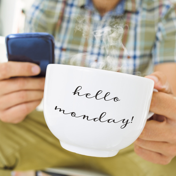 молодой человек с чашкой с текстом hello monday
 - Фото, изображение