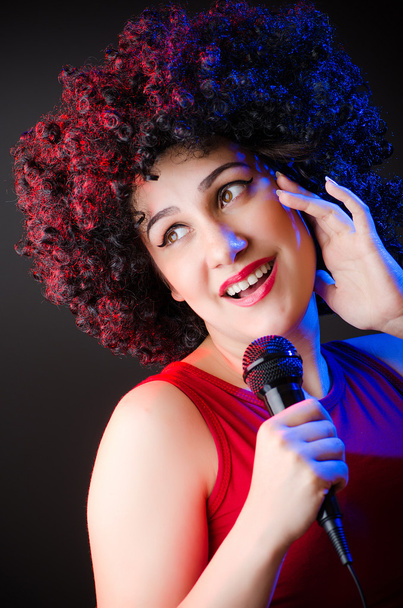 Femme à la coiffure afro chantant au karaoké
 - Photo, image