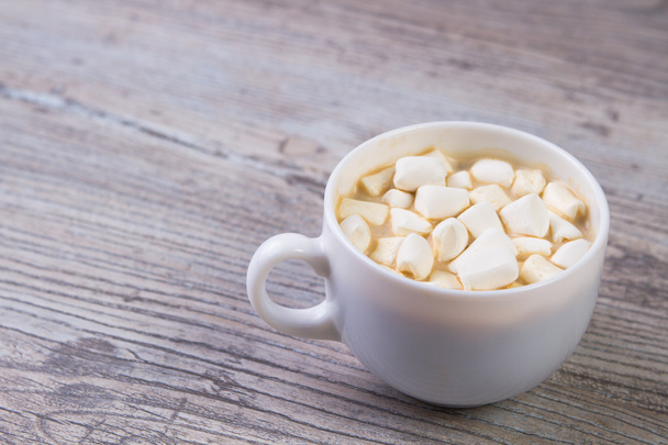 white Cup of hot cocoa with marshmallows on a light wooden background - Photo, Image