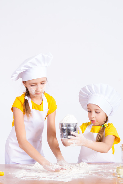 Children make the dough in the kitchen, roll a rolling pin - Фото, зображення