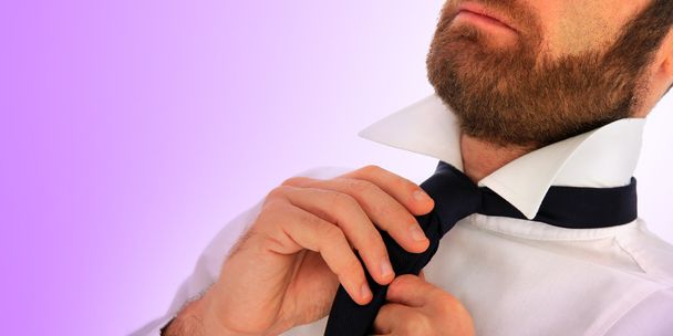 Elegante hombre de negocios ajustando su corbata
 - Foto, imagen