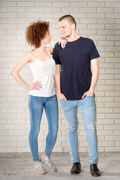couple standing against a background of a brick white wall - Zdjęcie, obraz