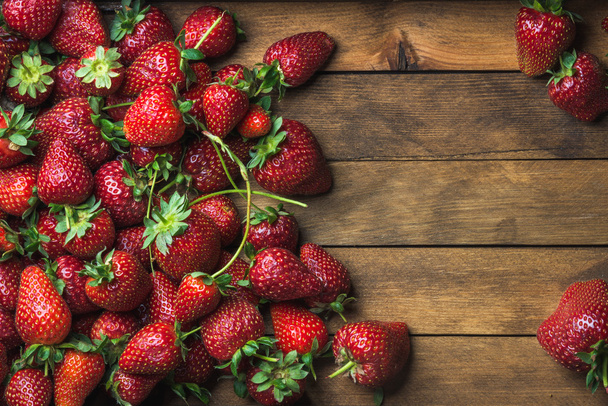 Strawberries over natural wooden background - Fotoğraf, Görsel