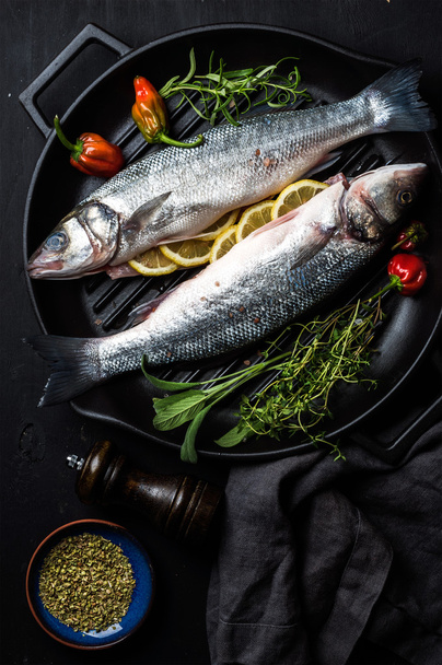 Raw uncooked seabass fish with herbs - Fotografie, Obrázek