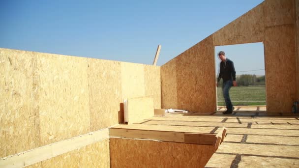 家を建てる男。発泡スチロール。合板と断熱材で作られたブロック。ハウスキーピング コテージ - 映像、動画