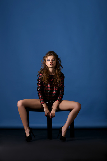 Sexy woman with bright make-up sitting on small coffee table - Fotó, kép